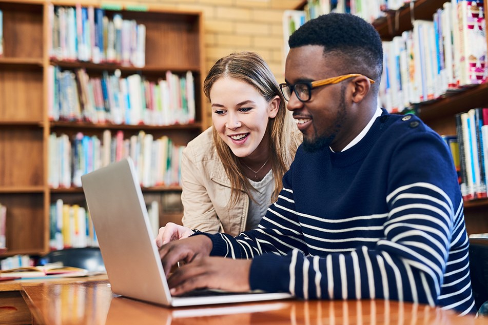 Two students working on a laptop